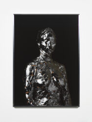 Photograph of figure wrapped in reflective silver tape