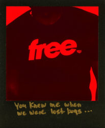 Black-and-red Polaroid of a torso, focusing on the text "free." on a t-shirt